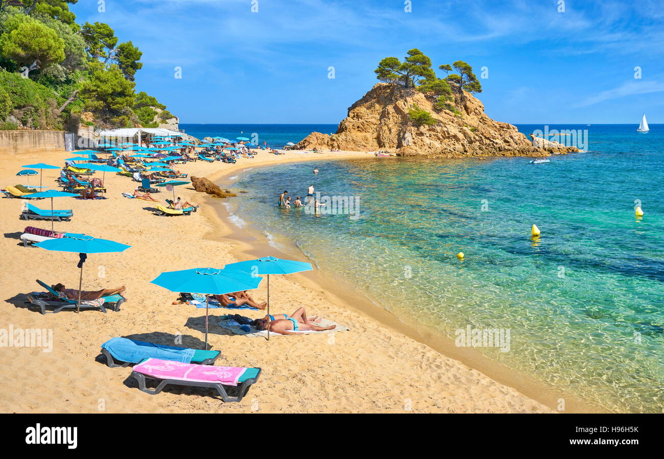 Beach chairs and sunshade at Cape Roig Beach, Costa Brava, Spain Stock Photo