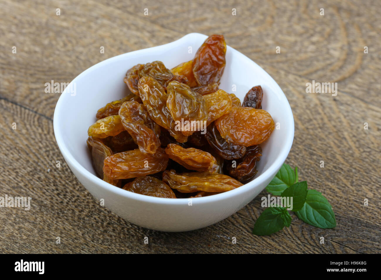 Sweet raisins in the bowl with mint leaves Stock Photo Alamy