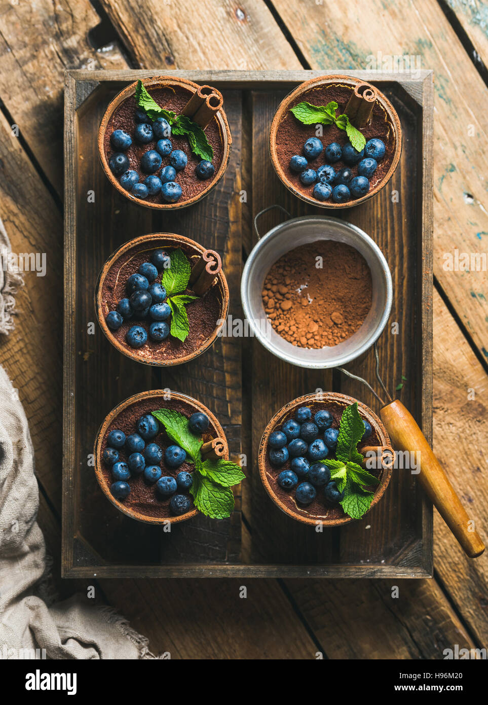 Homemade Tiramisu and sieve with cocoa powder in wooden tray Stock