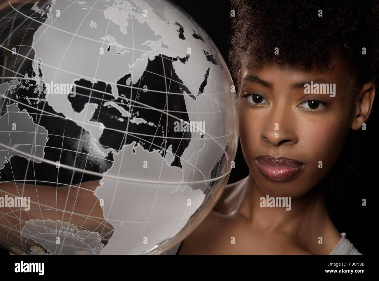 Young woman with transparent globe Stock Photo