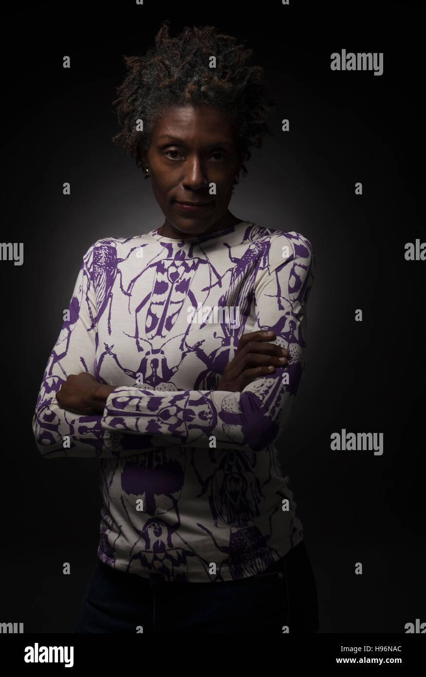 Studio shot of woman standing with arms crossed Stock Photo - Alamy