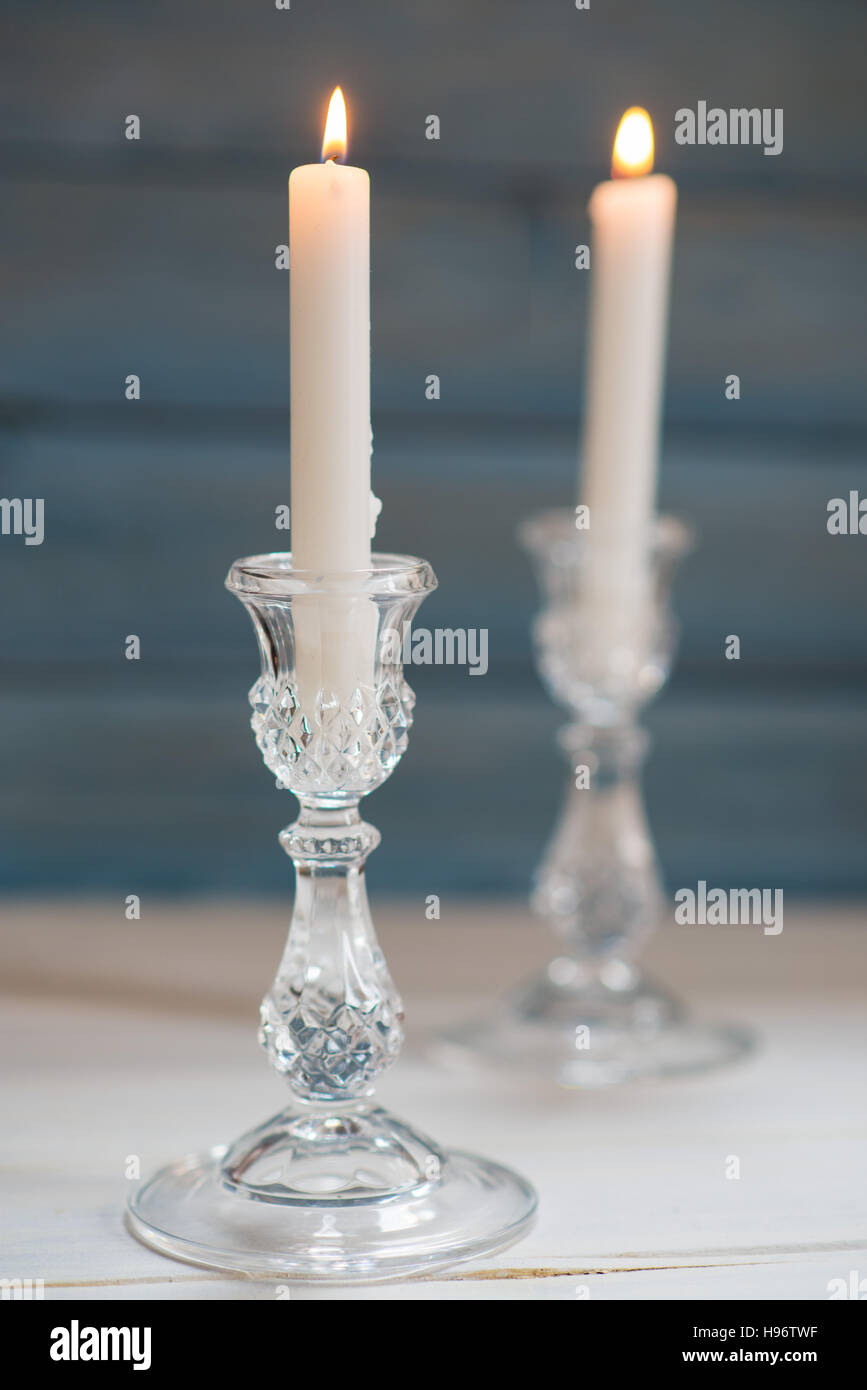 Two glass candlesticks with lit candles Stock Photo Alamy