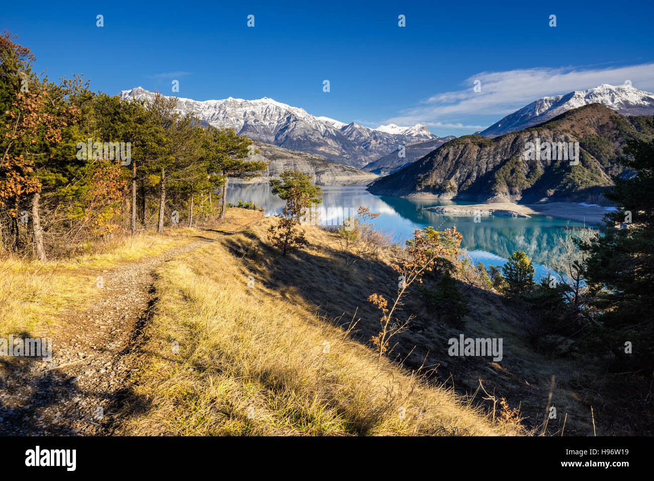 View from hiking trail of Serre Poncon Lake in Winter with snow covered mountains. Le Rousset, Hautes Alpes, Alps, France Stock Photo