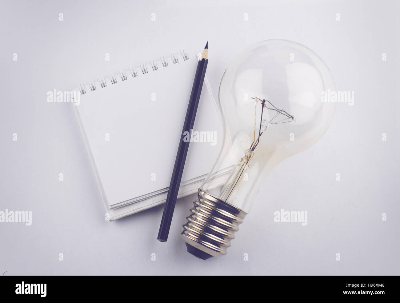 top view of black pen white empty notebook and a large light bulb Stock Photo