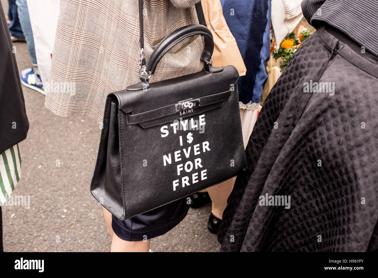 Close shot of woman wearing a black bag with the words 'Style is never for free' written on it Stock Photo