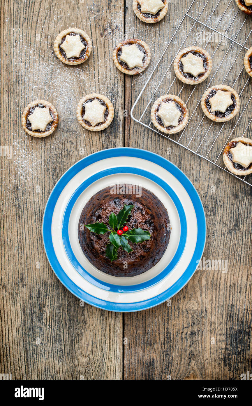 Christmas pudding on a plate from above with mince pies Stock Photo