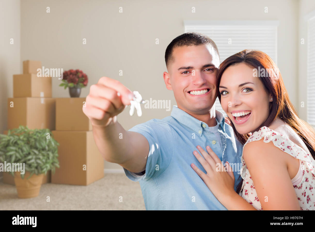 Happy Young Military Couple with House Keys in Empty Room with Packed ...