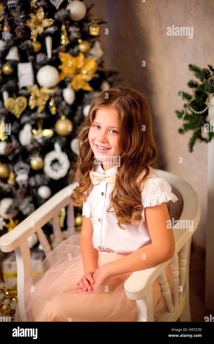 Little smiling girl sitting in soft chair Stock Photo - Alamy