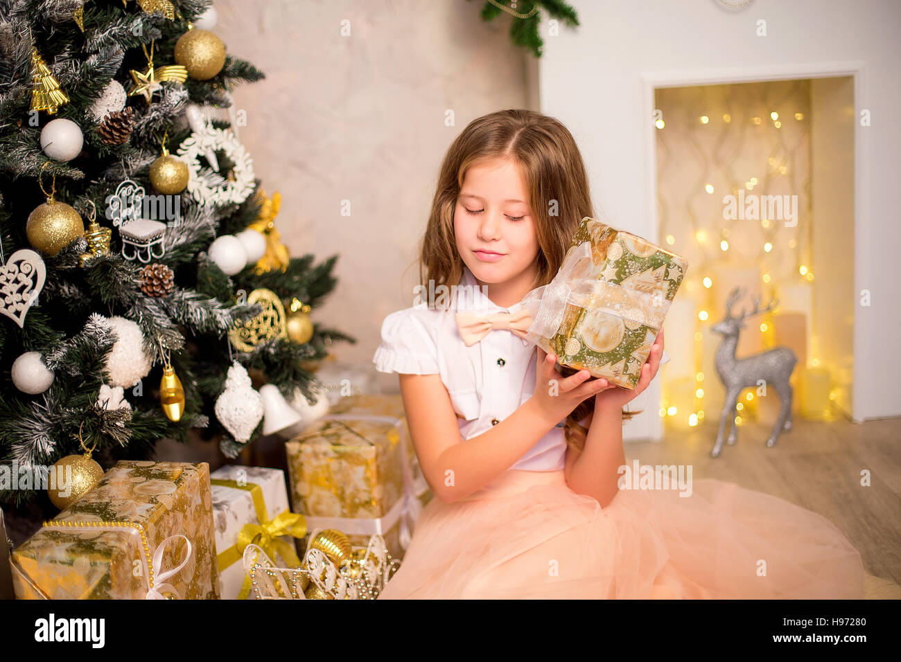 Girl holding Christmas present Stock Photo - Alamy
