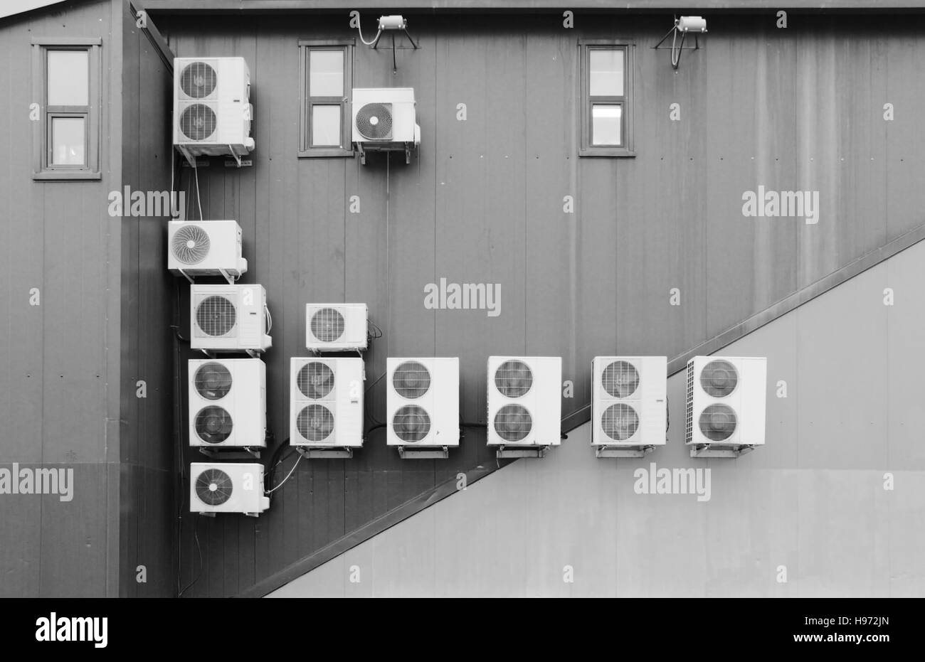 black and white photo several outer industrial air conditioners are cooling the air in a large shopping center in the summer Stock Photo