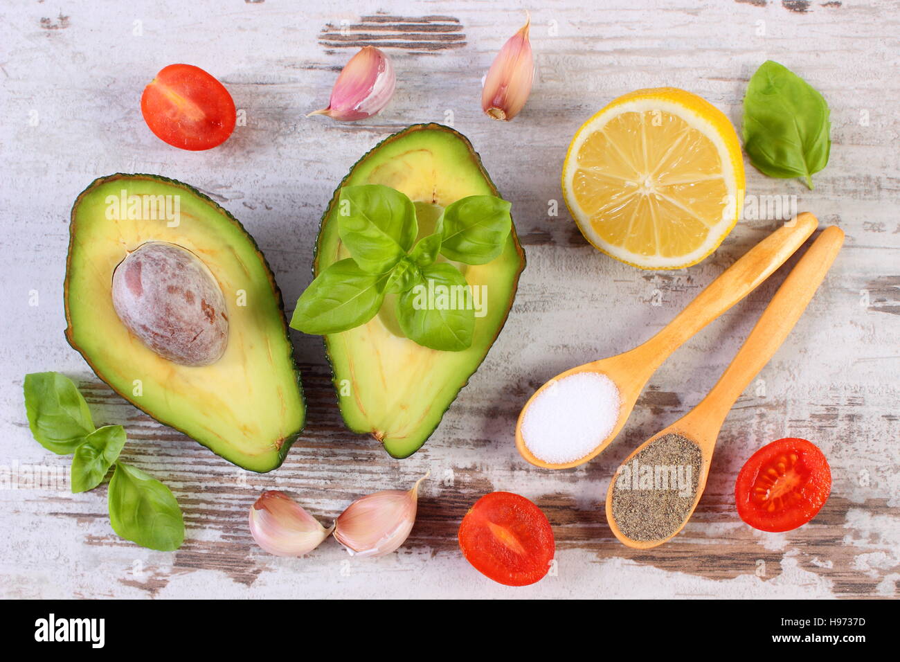 Avocado with ingredients and spices to avocado paste or guacamole, garlic, lemon, cherry