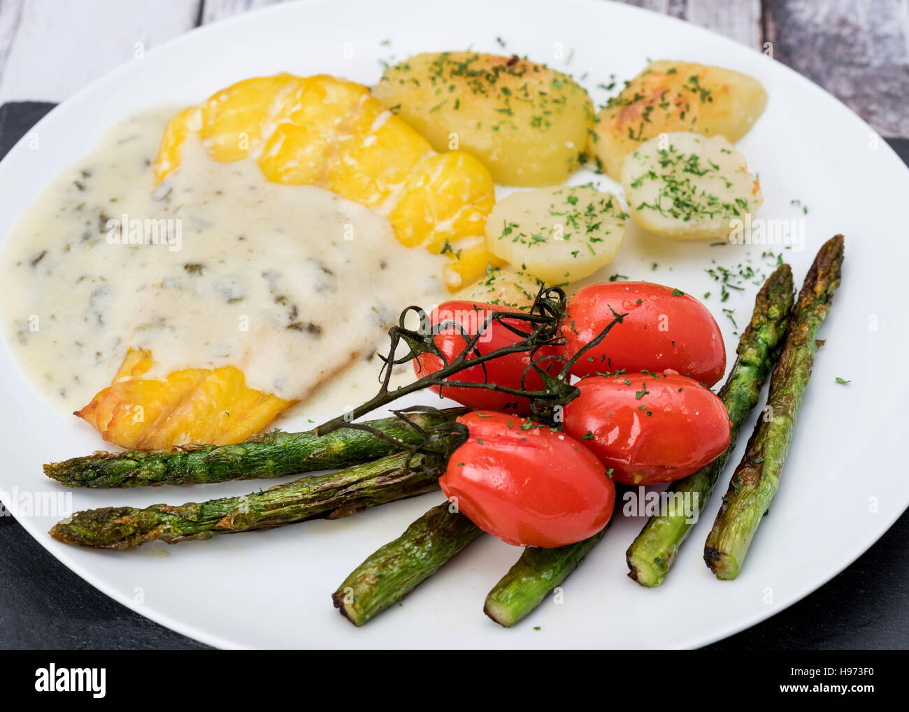 Smoked cod dinner with tartare sauce and vegetables Stock Photo