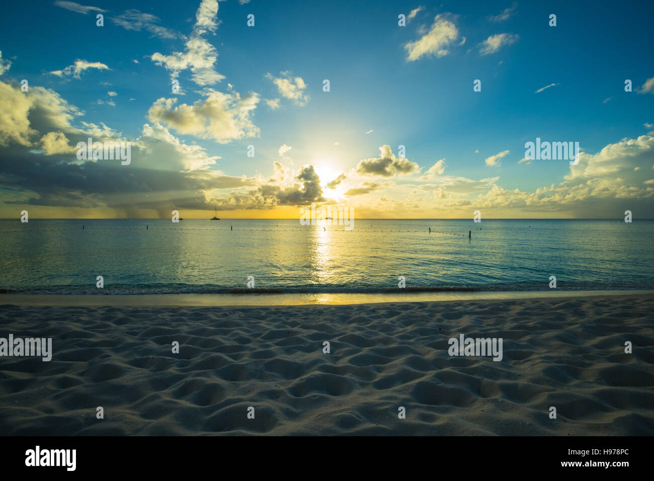 sunset over a tropical sea with golden sky and clouds Stock Photo - Alamy