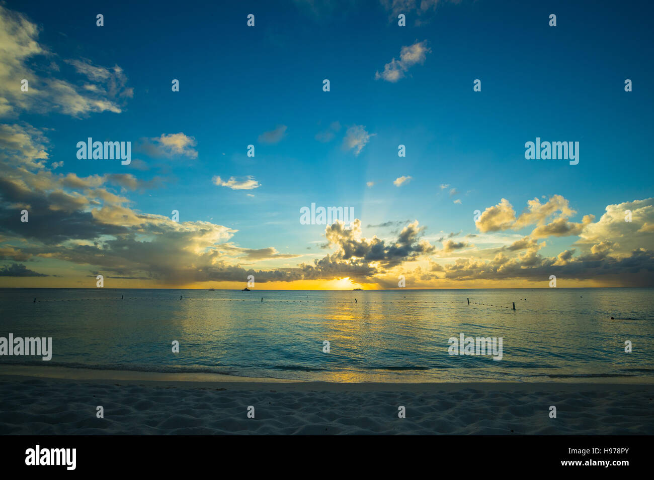 sunset over a tropical sea with golden sky and clouds Stock Photo - Alamy