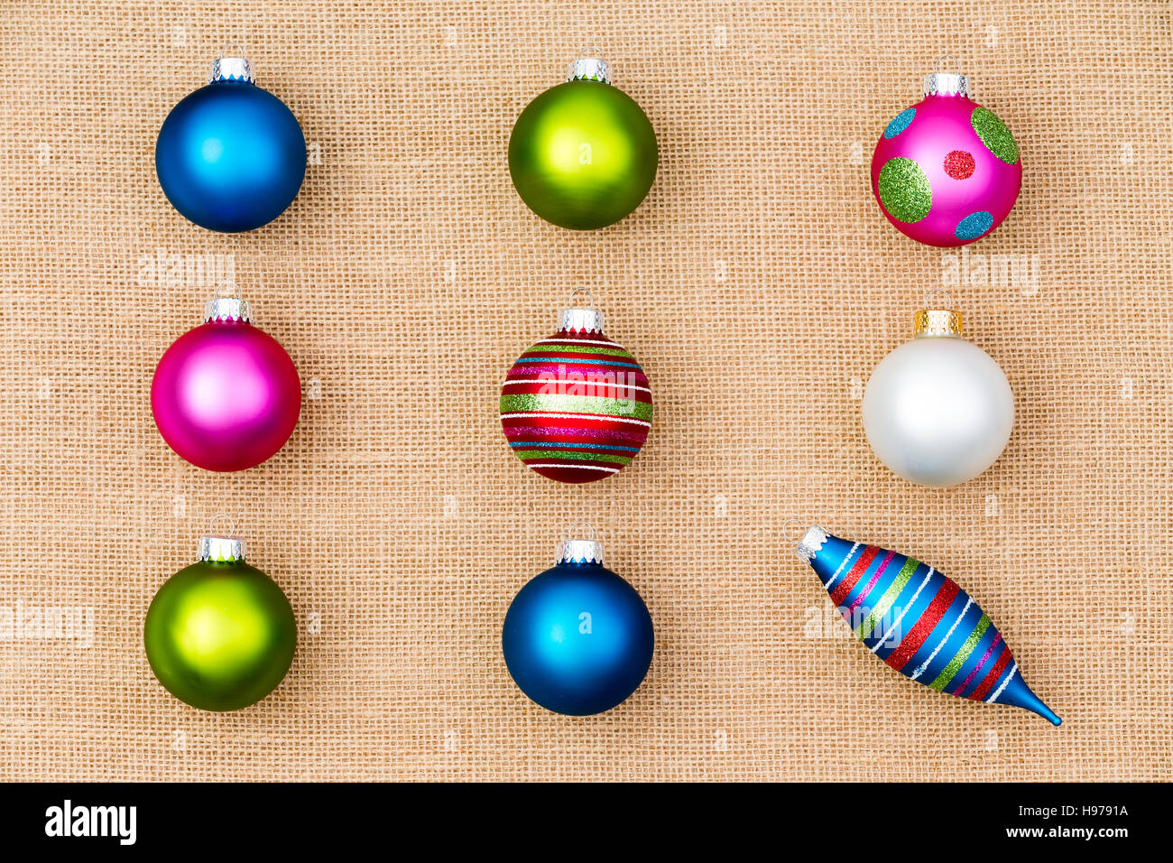 Festive Christmas still life with colorful Xmas tree ornaments arranged in neat rows of baubles with a single spindle conceptual of individualism and Stock Photo