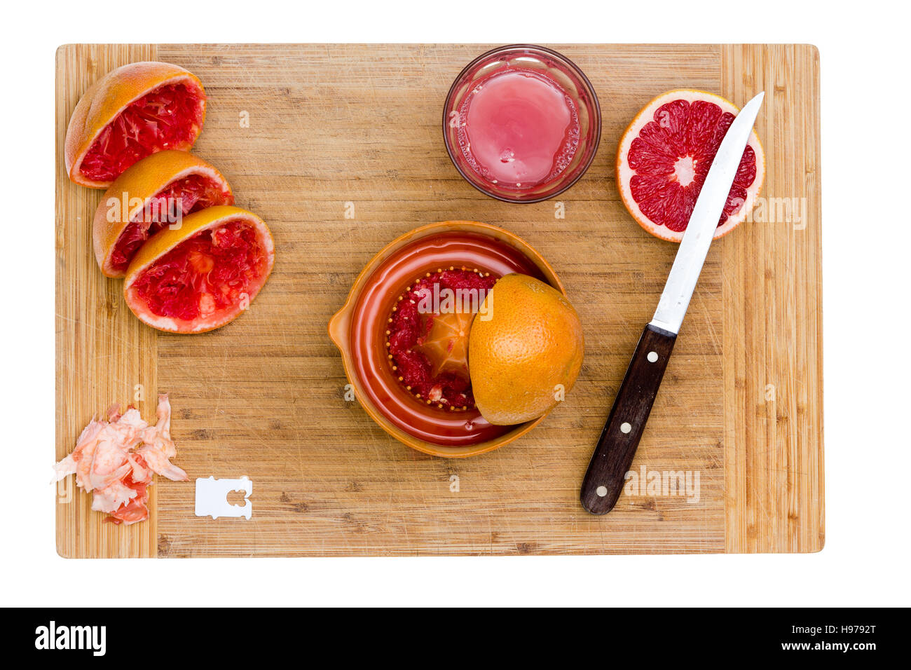 Fresh Grapefruits being Juiced, Ruby Red Grapefruit on Wooden Kitchen Board isolated on white Stock Photo