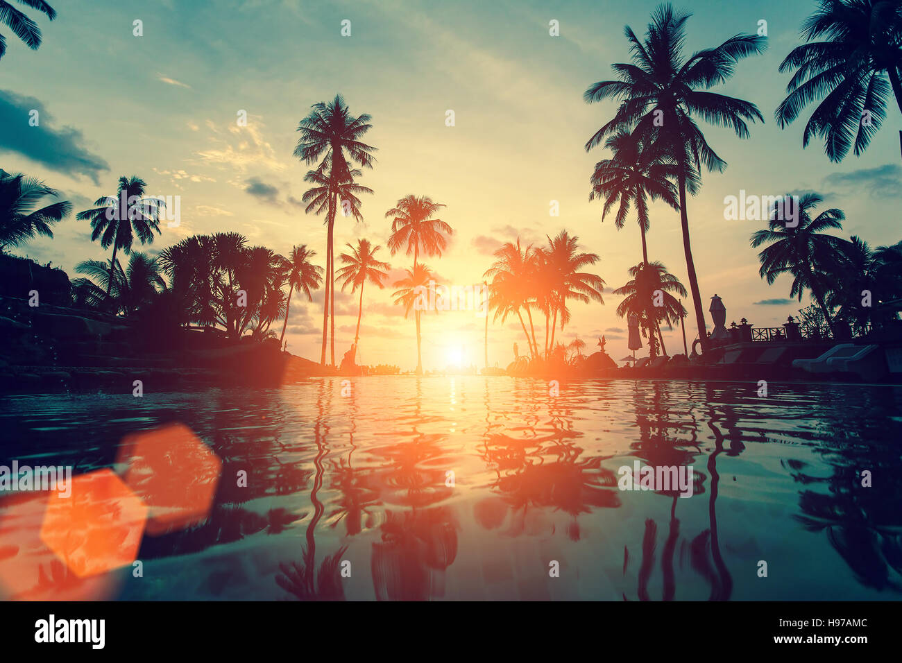 Fantastic sunset on a tropical beach with silhouettes of palm trees ...