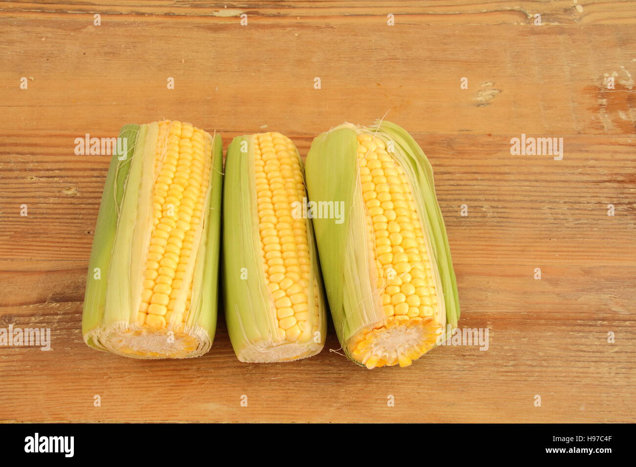Corn on the cob isolated on a wooden surface image in landscape format with copy space Stock Photo
