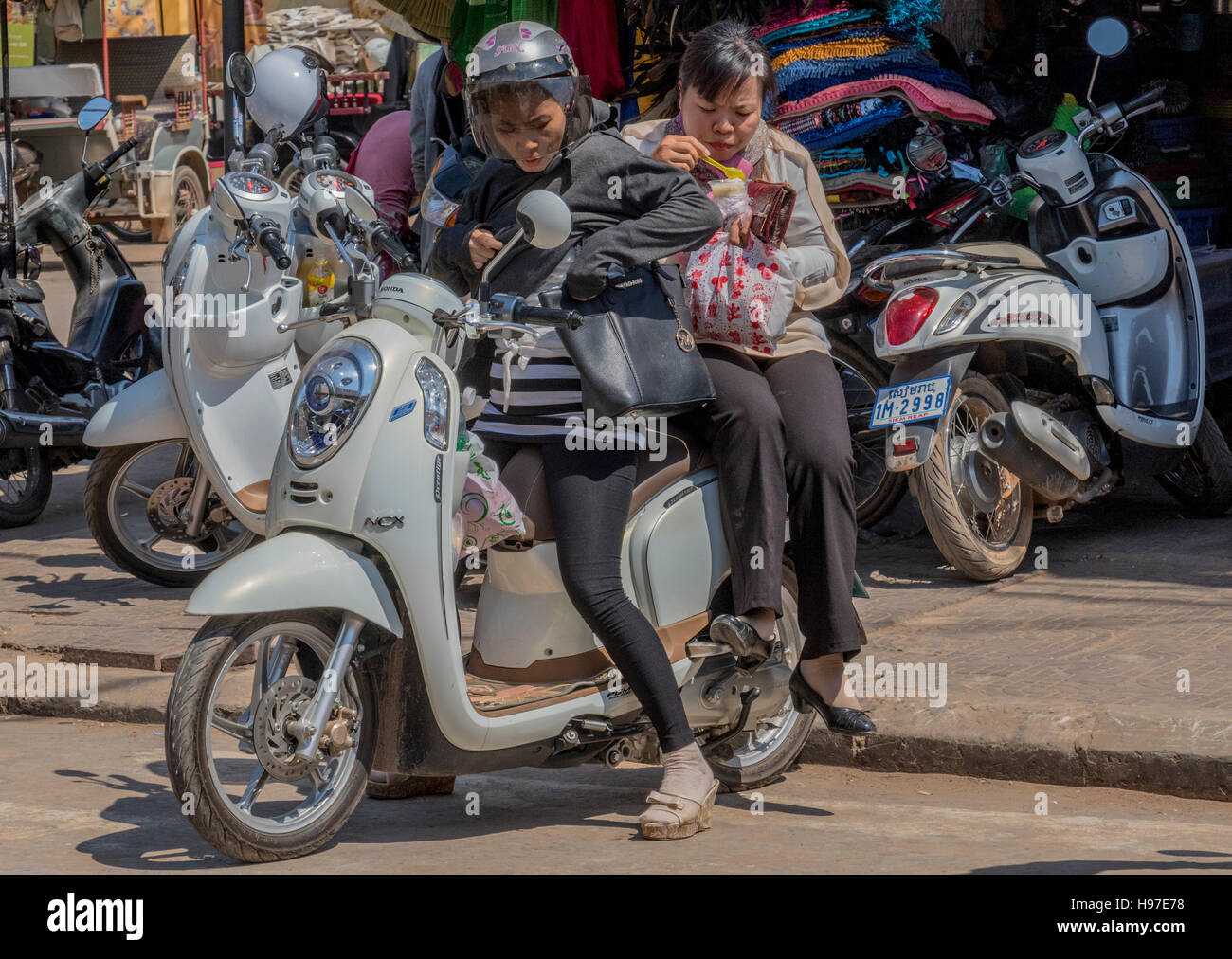 Two girls on motor scooter in Siem Reap Cambodia Stock Photo