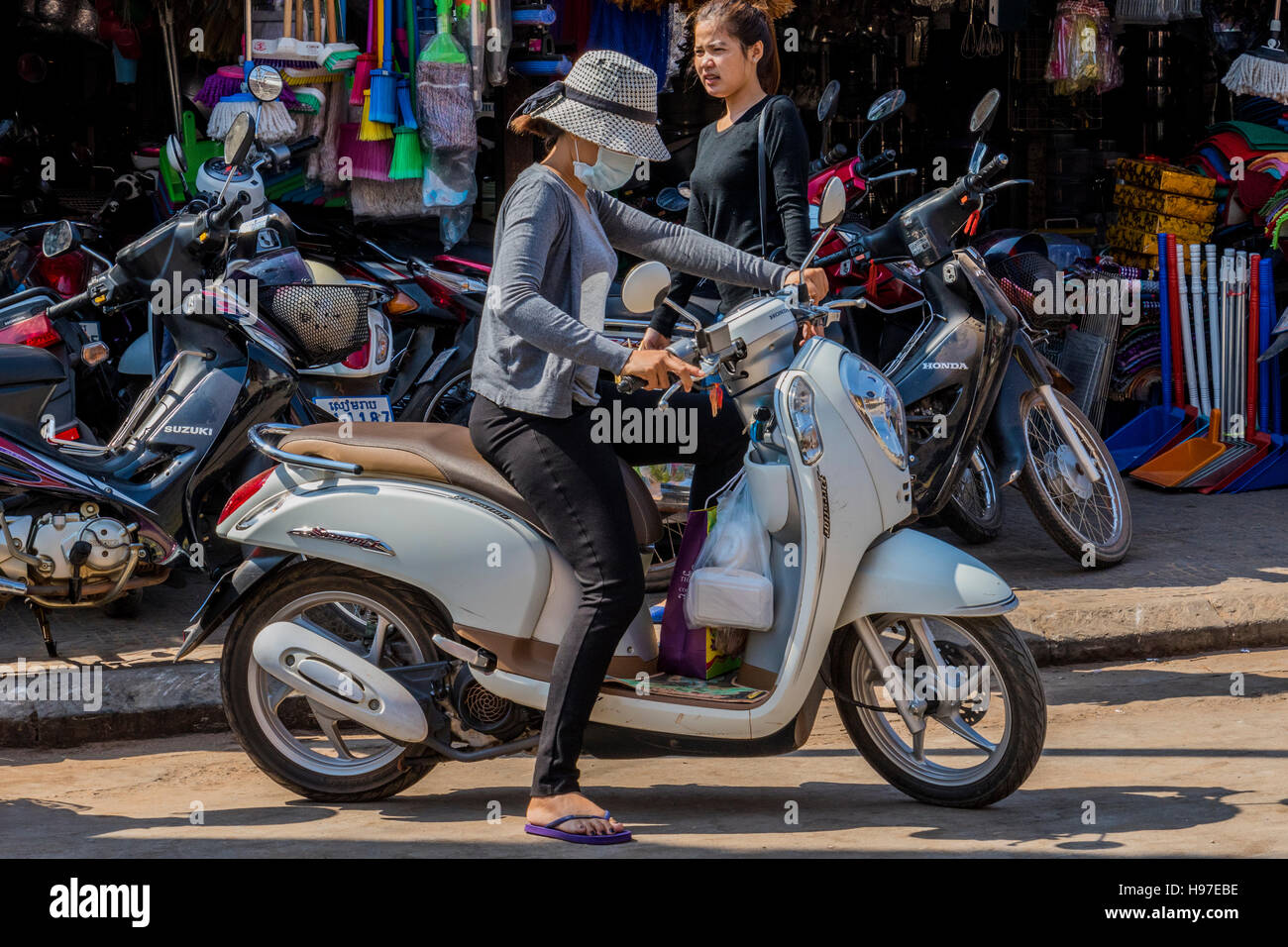 Girl in mask to protect her from polution on motor scooter in Siem Reap  Cambodia Stock Photo - Alamy