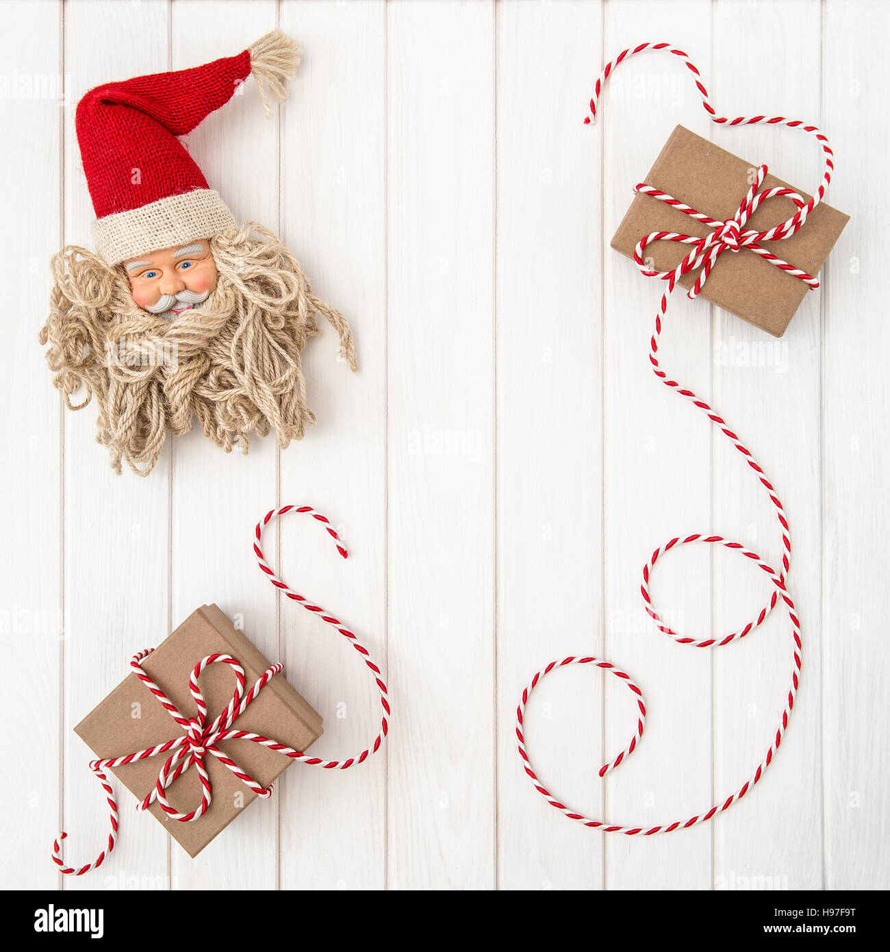 Christmas decoration with gift box and Santa Claus over bright wooden background Stock Photo