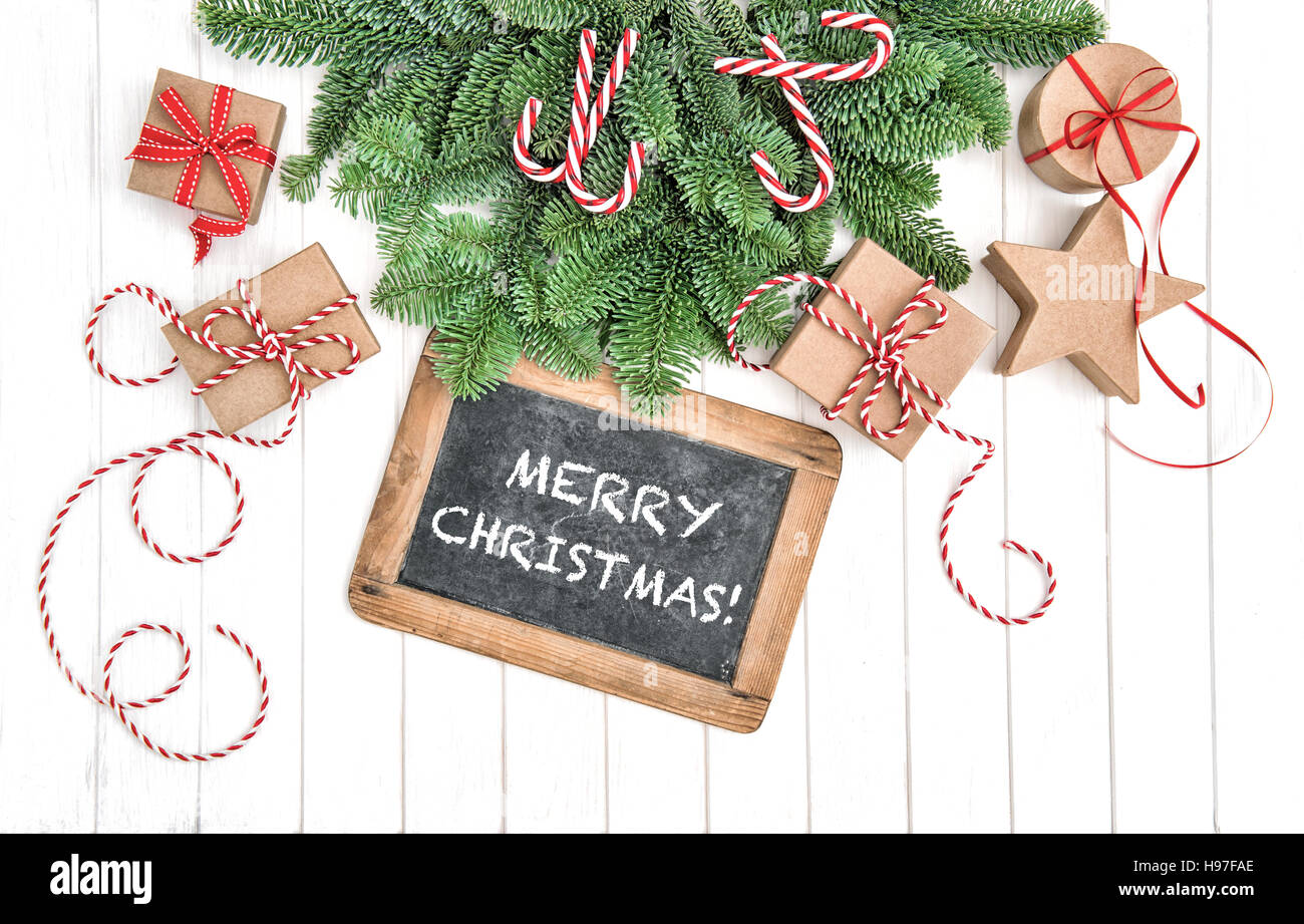 Christmas tree branches with chalkboard and gift boxes. Sample text Merry Christmas! Stock Photo