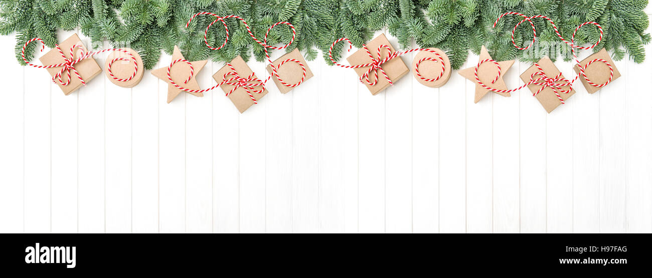 Christmas holidays banner. Christmas tree branches and gift boxes on wooden background Stock Photo