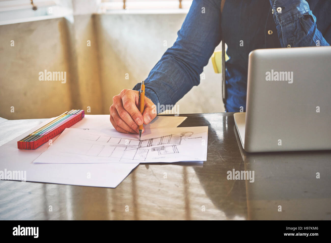 Architect man sketching a kitchen in his office Stock Photo