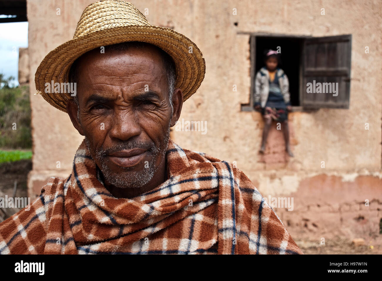 Man belonging to the Betsileo ethnic group. In the background, his granddaughter ( Madagascar) Stock Photo
