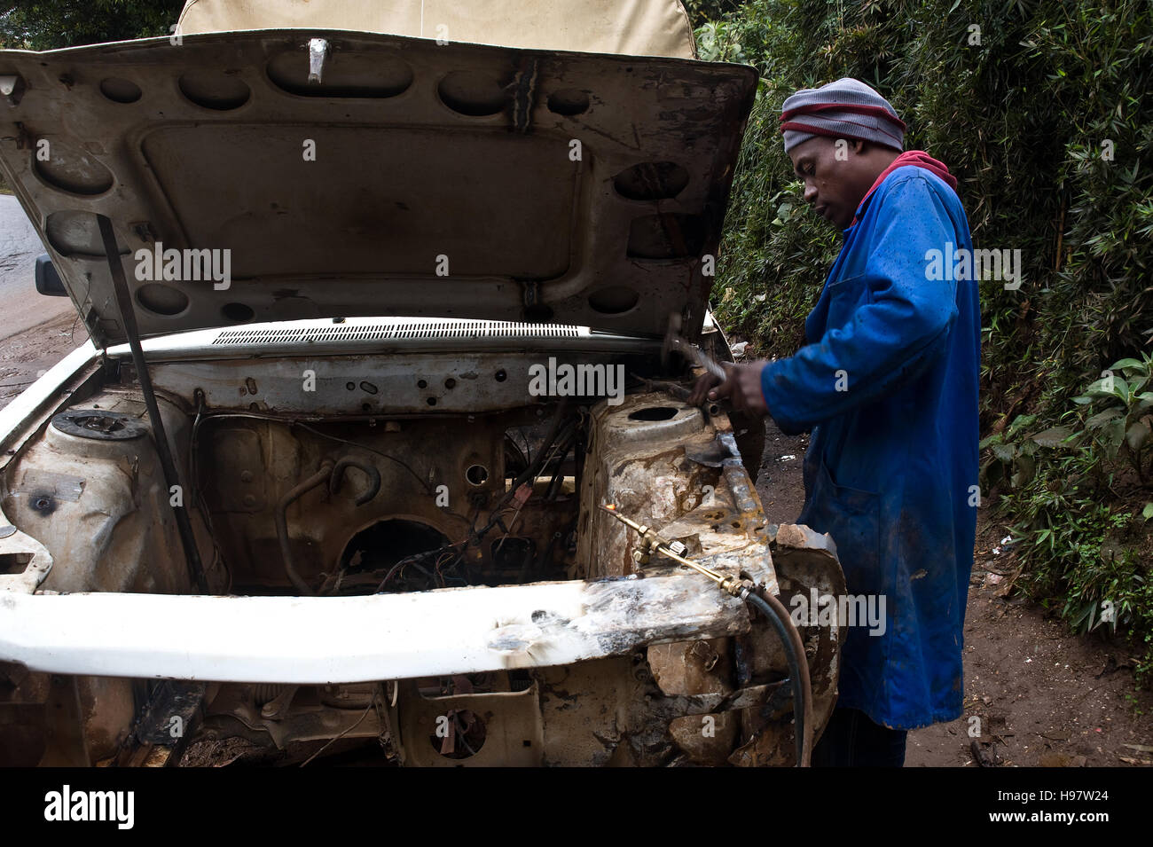 Auto mechanic repairing an old Peugeot 404 car ( Madagascar) Stock Photo