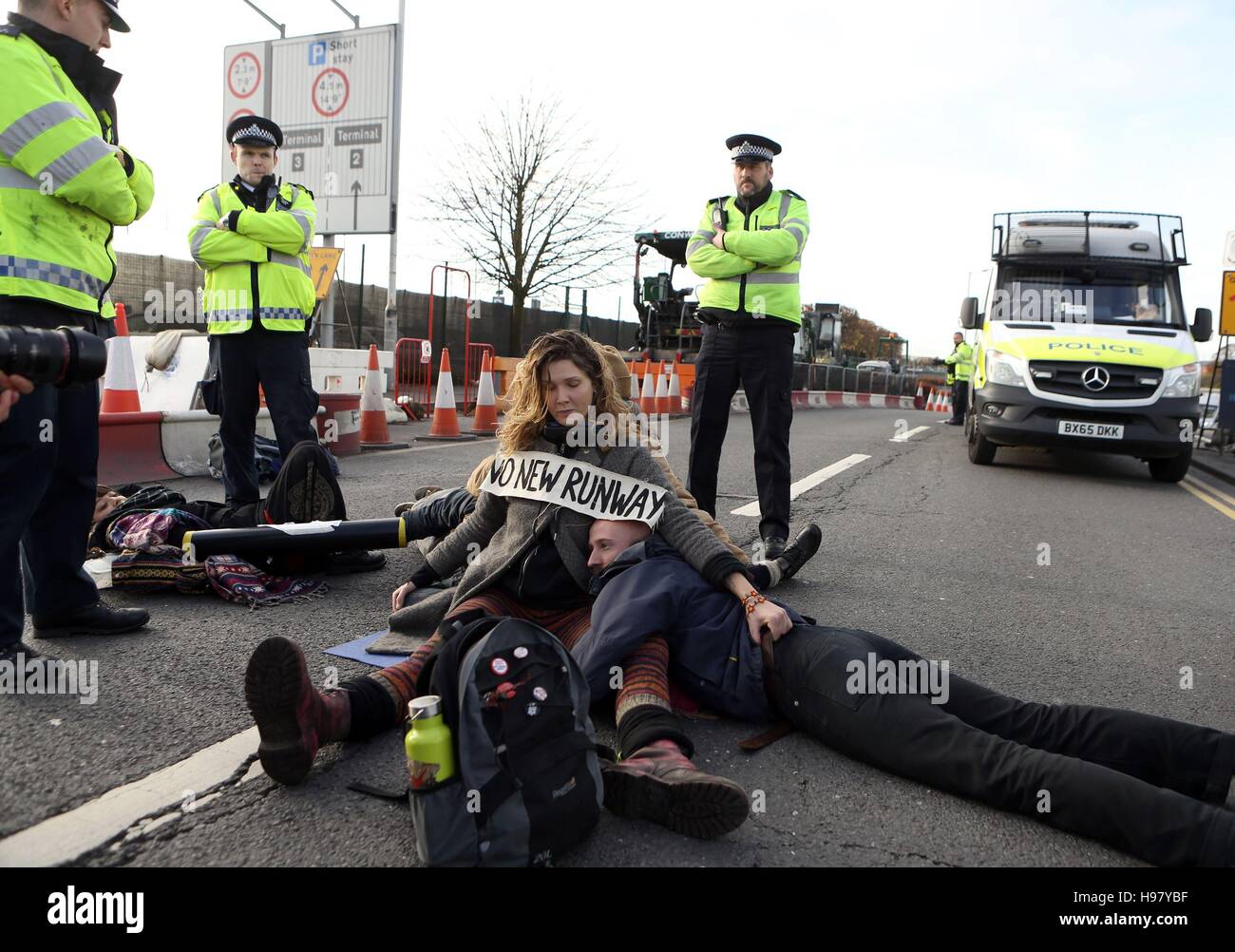 Protestors from campaign group RisingUp! lock themselves together as they block the east ramp at Heathrow Airport, in protest over the development of a third runway. Stock Photo