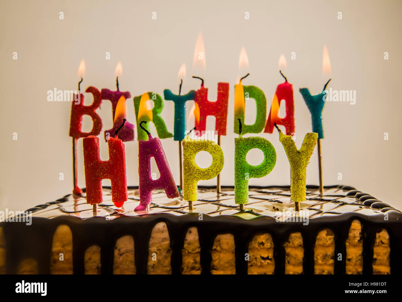 Happy birthday candles burning on chocolate cake isolated on white or ...
