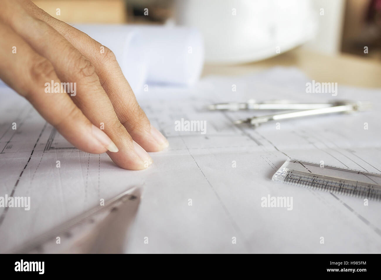 Close-up Hands of Engineer working on blueprint,Construction concept. Engineering tools.Vintage tone retro filter effect,soft focus(selective focus) Stock Photo