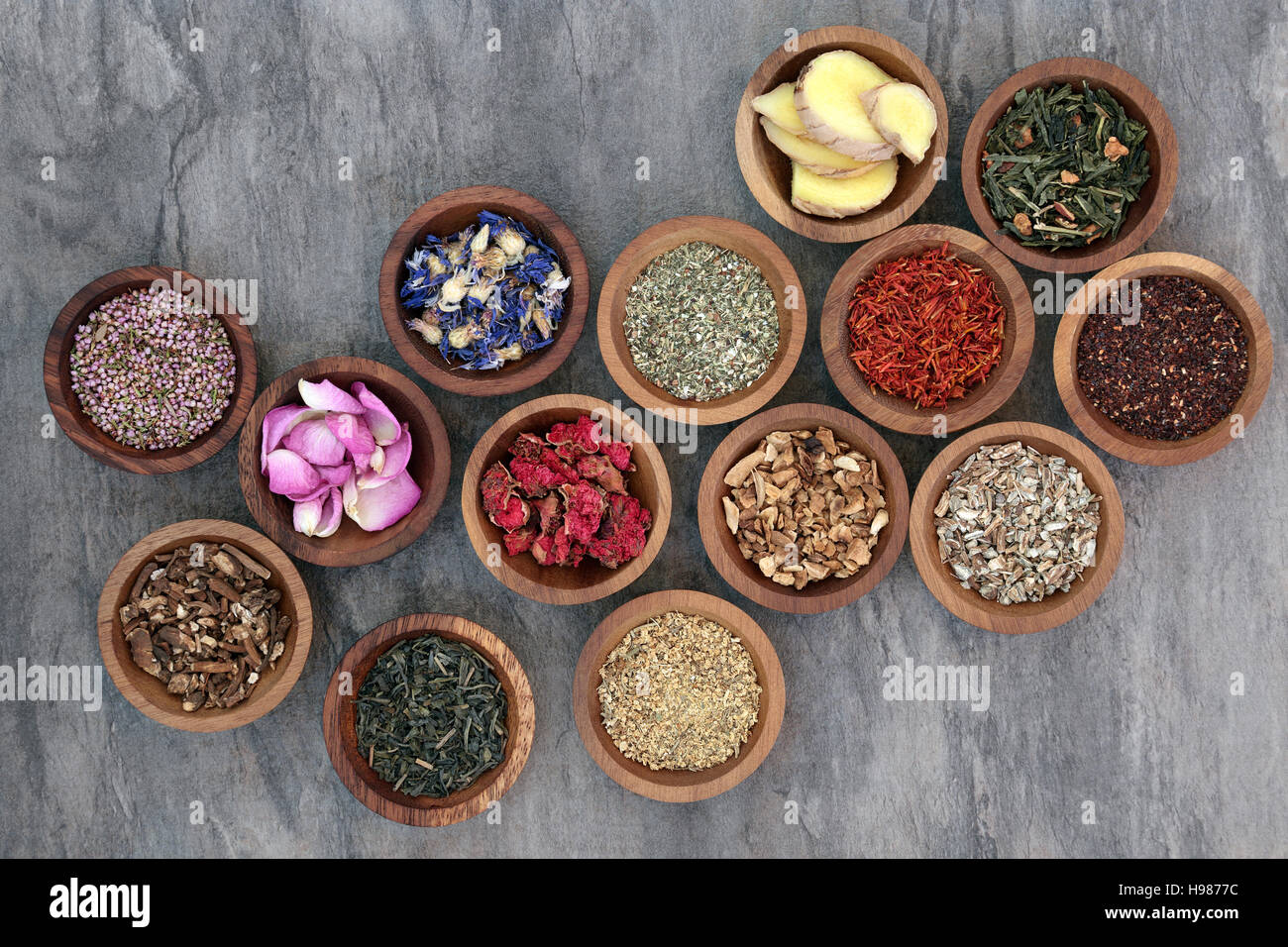 Herb tea collection in wooden bowls also used in natural alternative medicine. Stock Photo