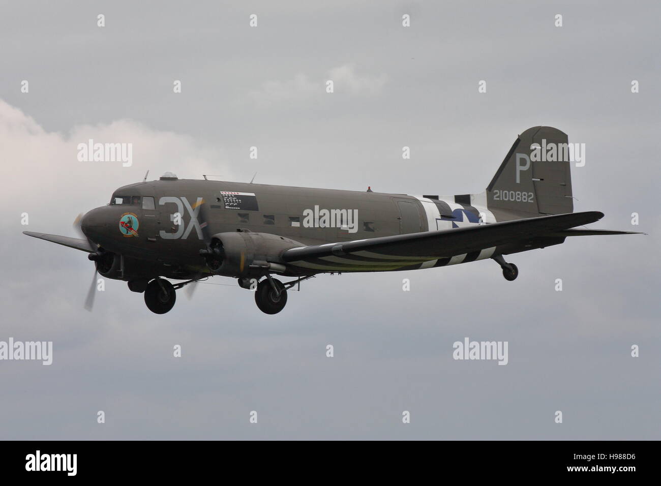 Douglas C-47A Skytrain, military version of the DC-3 Dakota,in USAAF D-Day markings making a flypast at Abingdon, UK Stock Photo