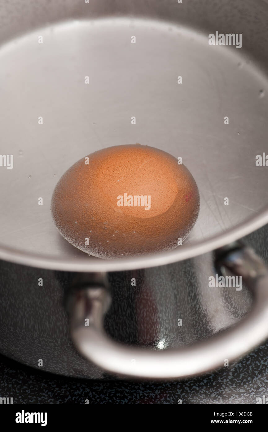 Egg in boiling water, in a saucepan Stock Photo