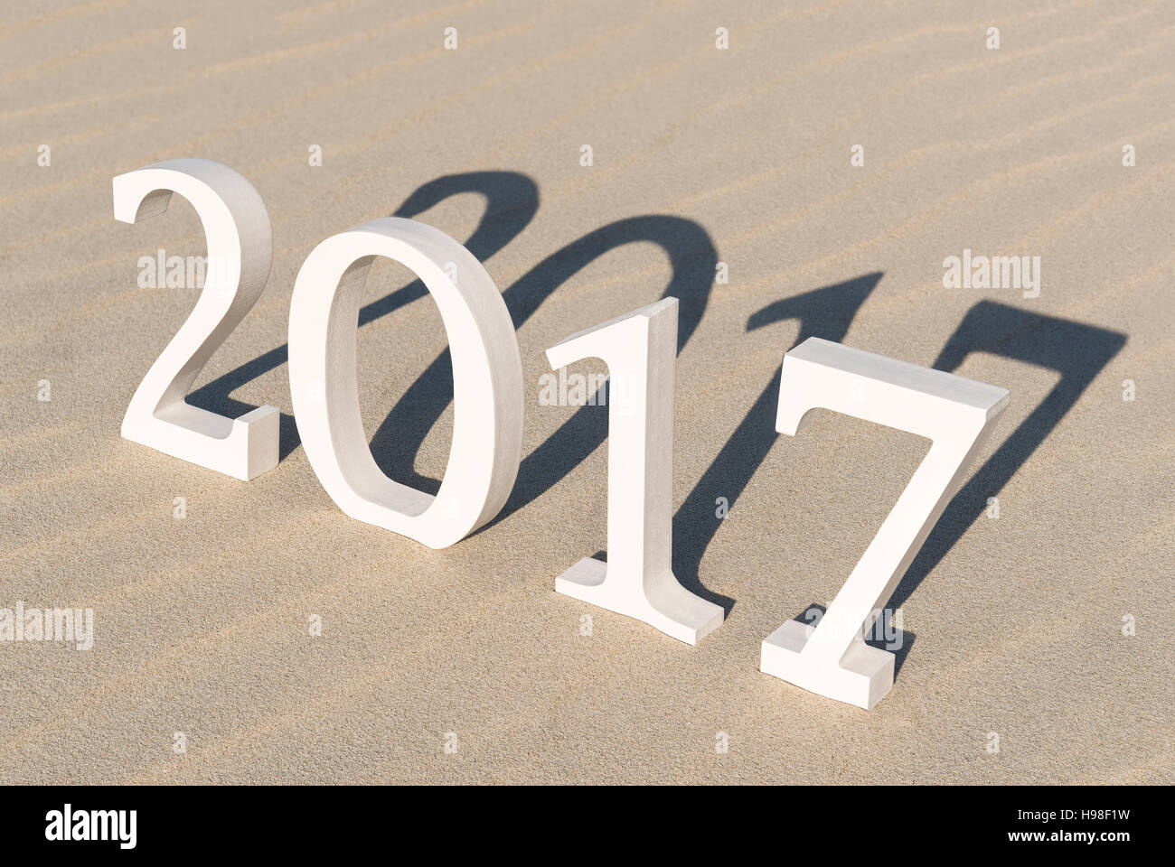 White wood figures on a beach forming the text two thousand seventeen as conceptual welcoming of the coming new year Stock Photo