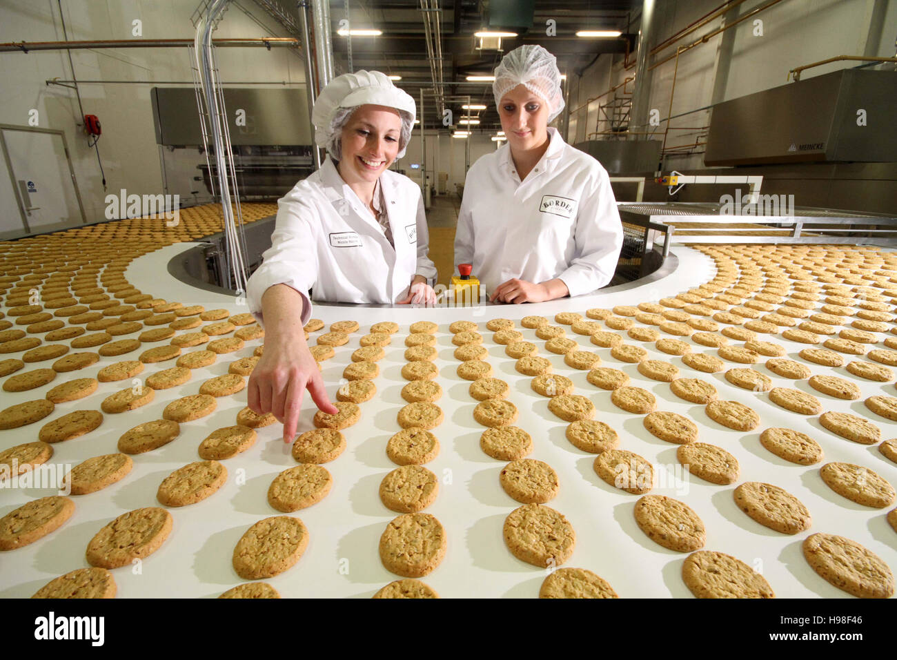 Production line with biscuits and factory workers Stock Photo