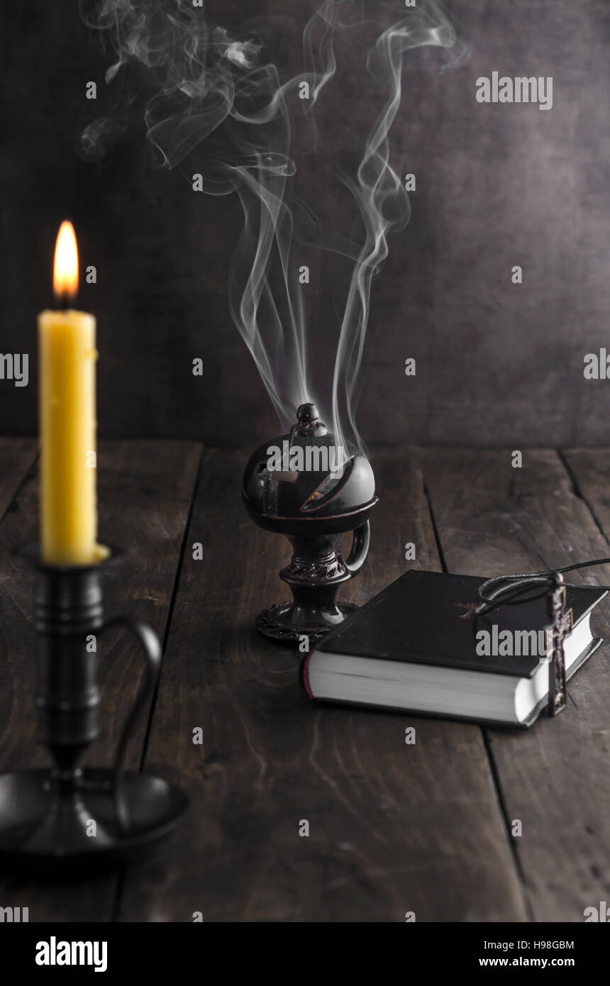 Antique candlestick and burning candle and in the background a incense ...