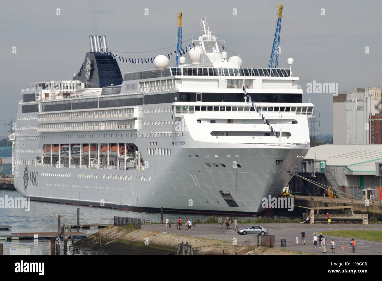The cruise ship MSC Opera anchored at Southampton docks, the people in the foreground provide a sense of scale. Stock Photo