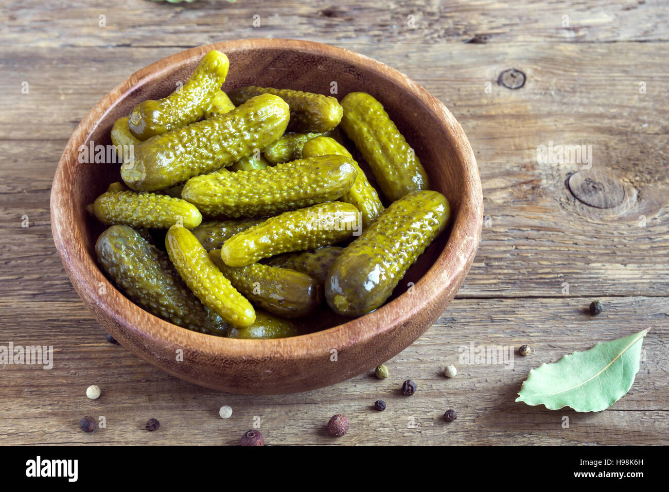 Pickles. Bowl of pickled gherkins (cucumbers) over rustic wooden background with copy space. Stock Photo