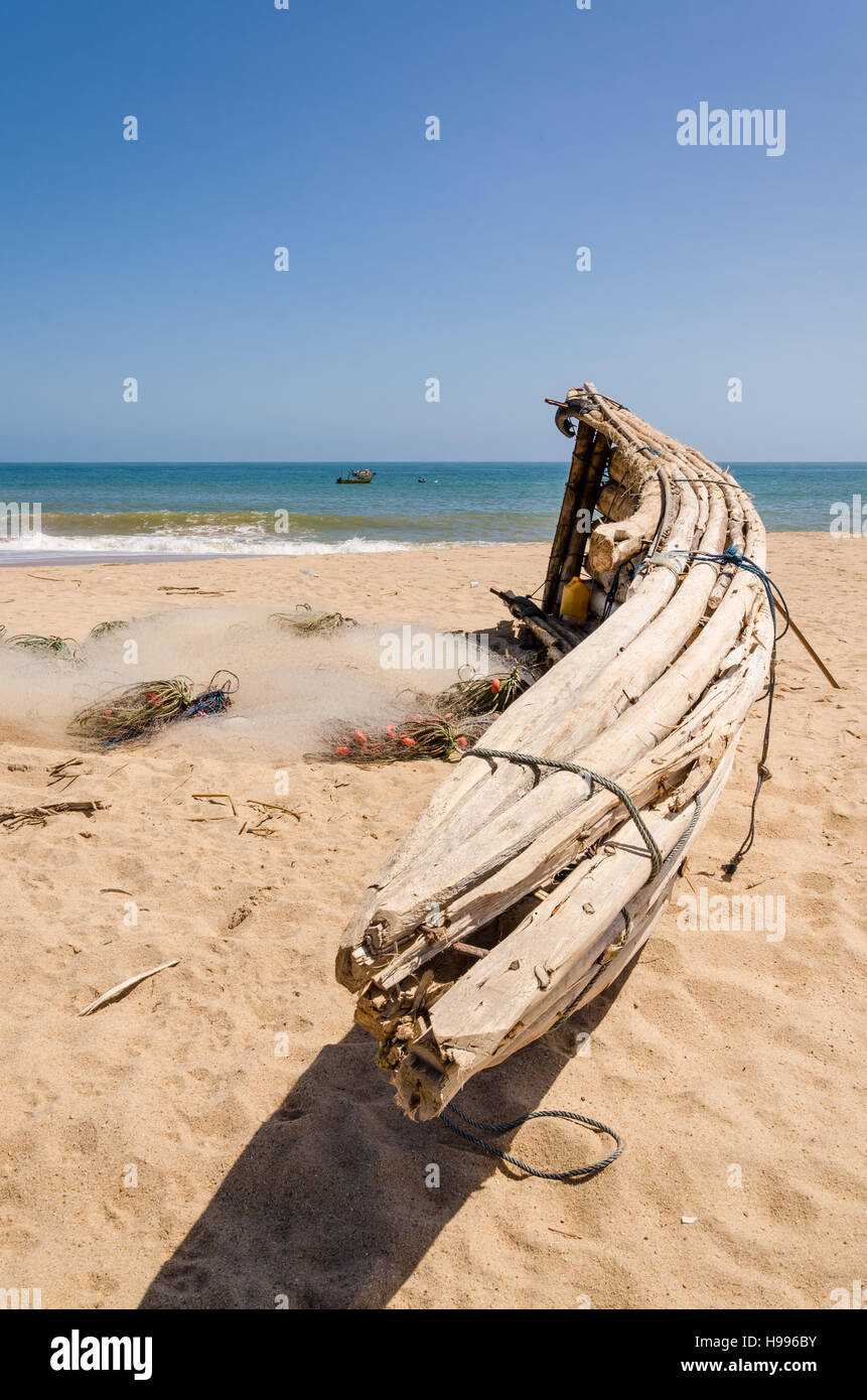 Crude wooden fisher boats lying on yellow beach near Lobito, Angola. These boats have been used traditionally by the locals but nowadays plastic nets Stock Photo