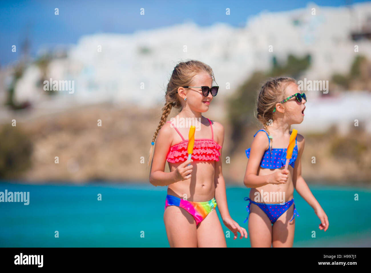 Happy little girls eating ice-cream on the beach Stock Photo - Alamy