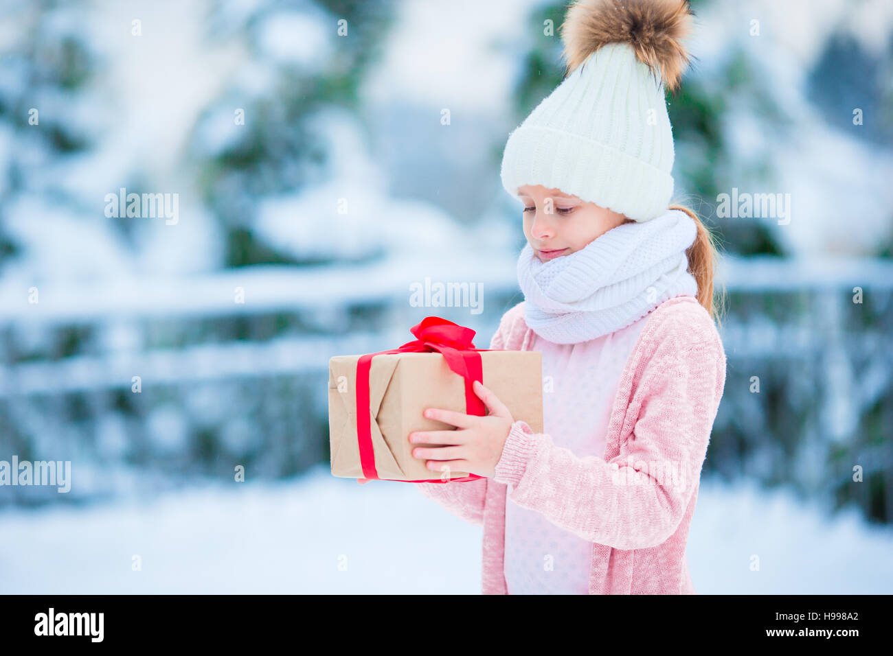 Little girl with gift in frozen forest on Christmas eve Stock Photo - Alamy