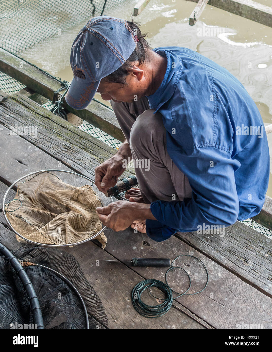 Local fisherman works with fishing nets near Pulau Kukup National Park