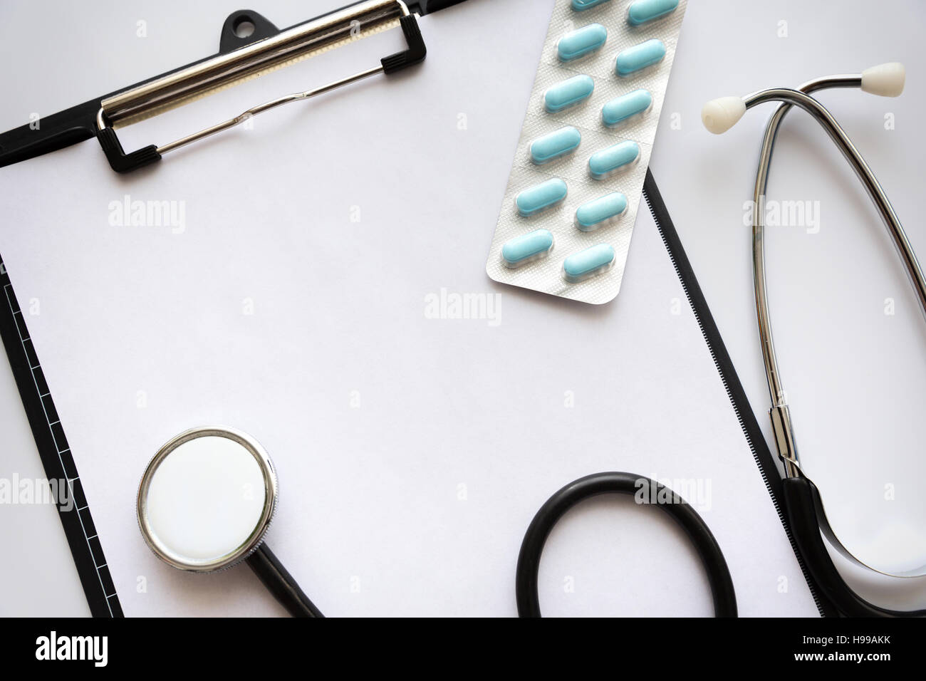 Empty medical file with stethoscope on top of it,next to pills. Top ...
