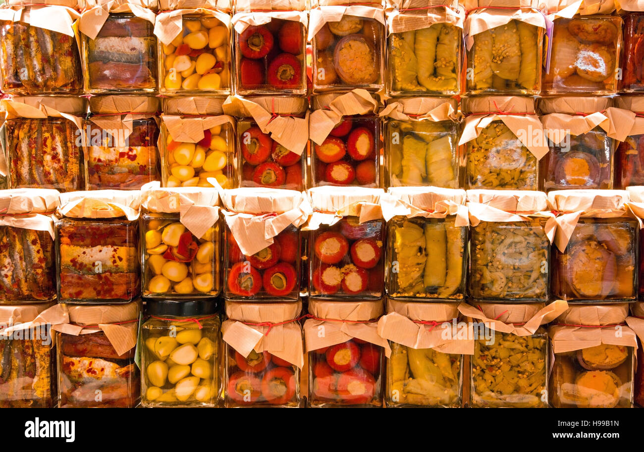 many jars with preserved italian food with vegetables and garlic and sardines in oil Stock Photo