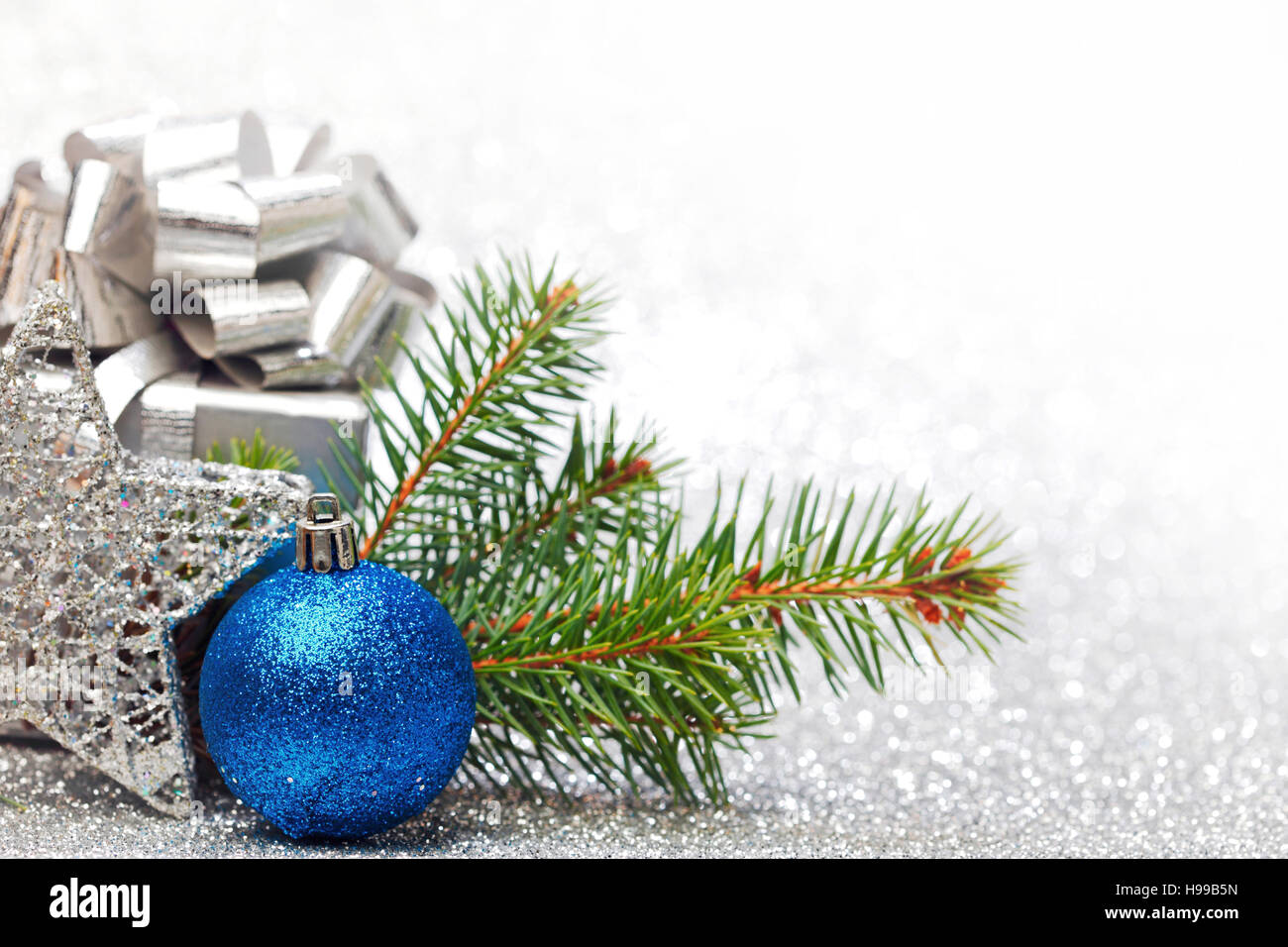 Christmas fir tree branch and decoration on silver glitter background ...