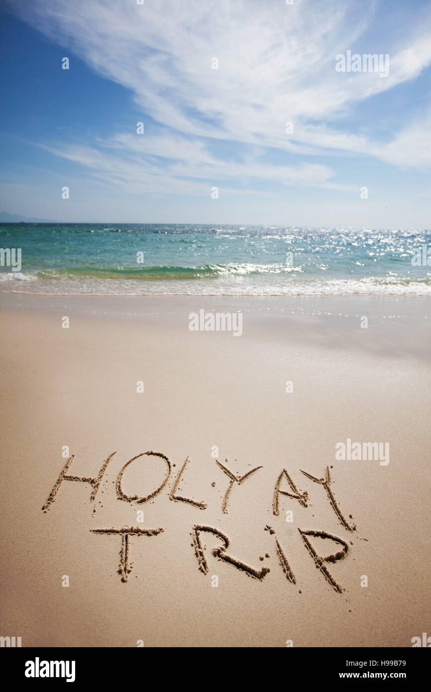 Holiday trip handwriting on tropical sea beach Stock Photo