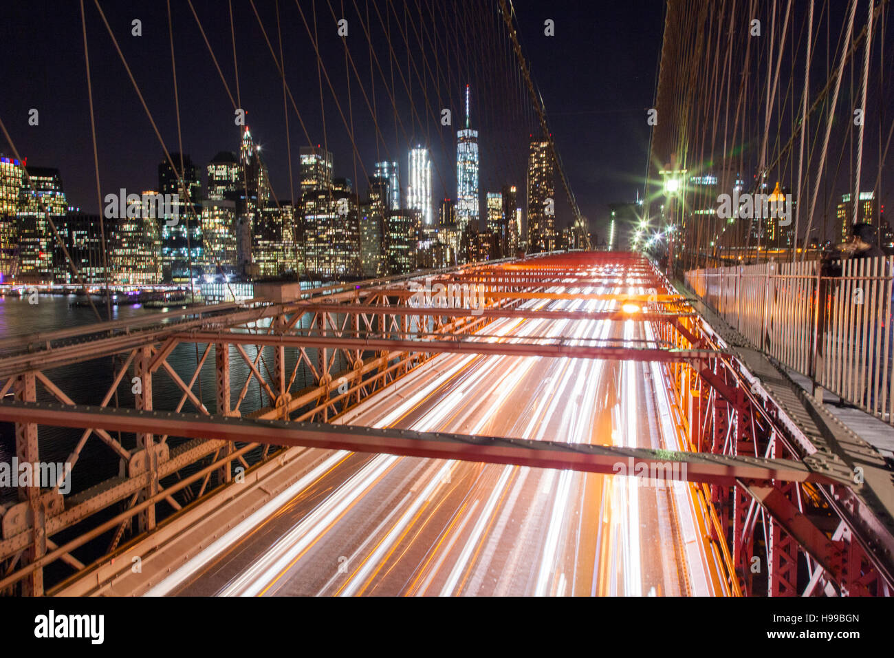 Brooklyn bridge at night with  car light trails and the financial district in the background , United States of America. Stock Photo